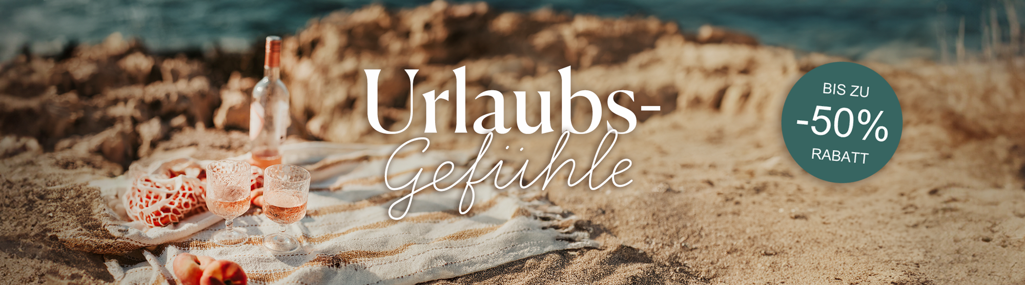 Urlaubsstimmung am Strand mit einem Picknick, Roséwein und Text "Urlaubs-Gefühle" und "-50% Rabatt".