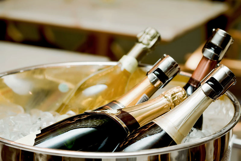 Mehrere Wein- und Champagnerflaschen liegen in einem Eiskübel.